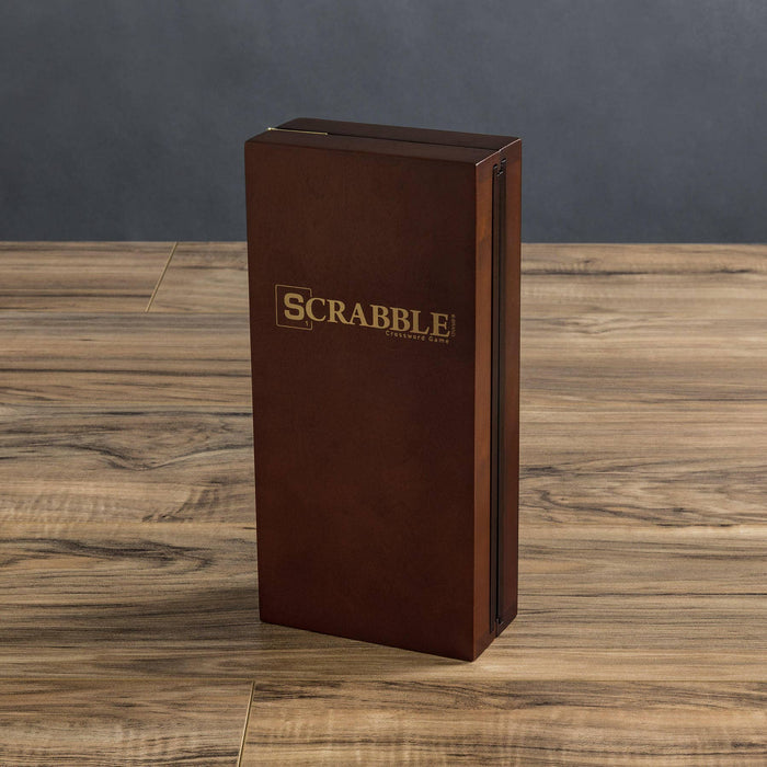 Brown wood Scrabble Travel Edition game box on a wooden surface with a dark gray background
