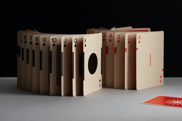 Playing cards arranged in a circular pattern on a gray surface with a black background
