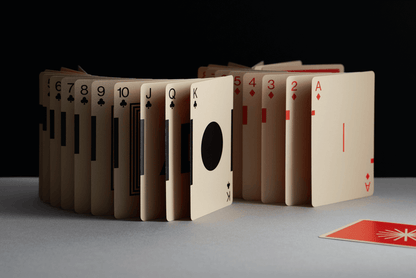 Playing cards arranged in a circular pattern on a gray surface with a black background