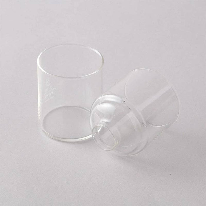 Two clear glass cups on a light gray background