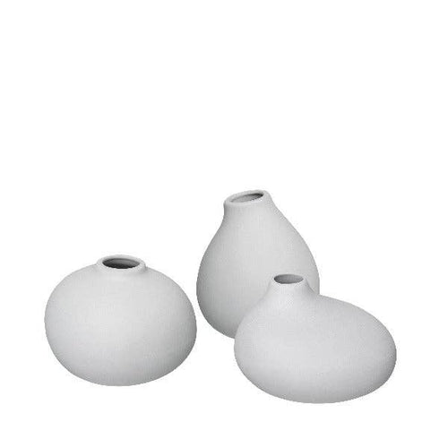 Three light grey ceramic vases of different shapes on a white background