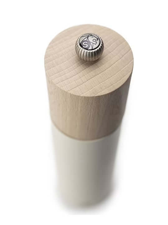 White salt grinder with a wood top with metal logo button on a white background