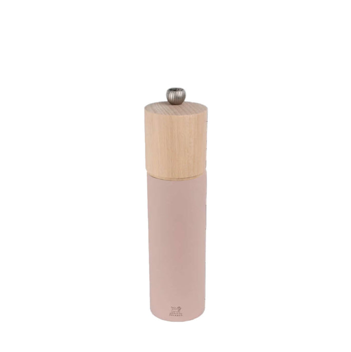 Pepper grinder with wooden top and pink body on a white background