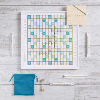Scrabble board game set on a wooden surface with tiles and bags.