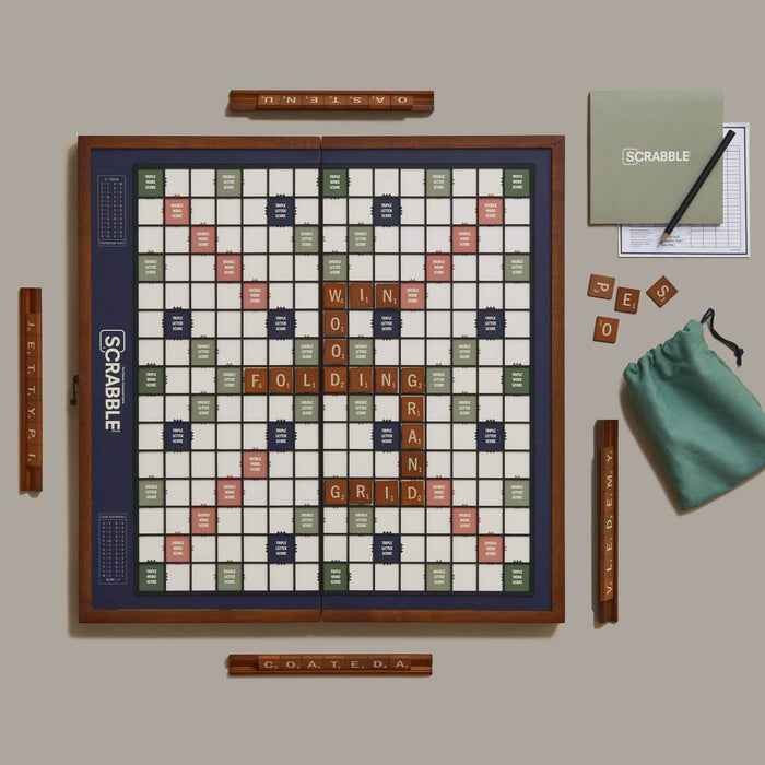 Scrabble board game set with tiles and accessories on a beige surface